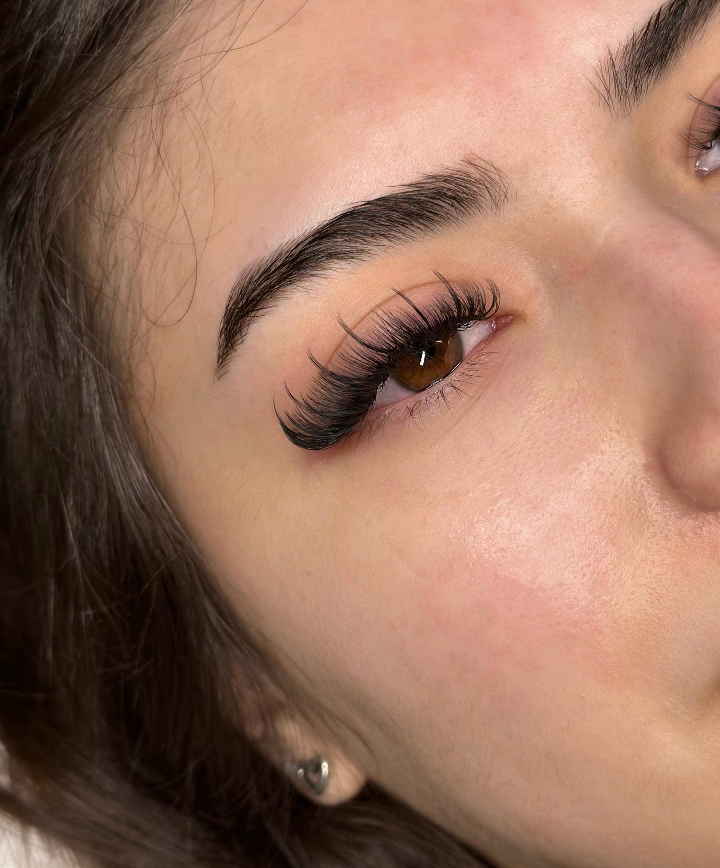 Brown-eyed client with a soft volume set, close-up